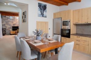 Villa Achlia في Achlia: غرفة طعام مع طاولة وكراسي خشبية