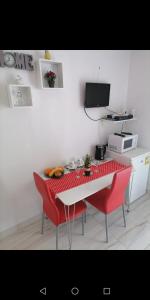 a kitchen with a table and two red chairs at Room Dragica in Dubrovnik