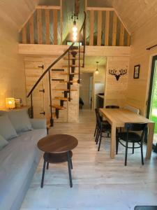 a living room with a table and a staircase at Ostoja Orżyny, Dom nr 2 - Zielono mi in Dźwierzuty