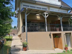 een huis met een omheinde veranda en een balkon bij Villa Pelso in Balatongyörök