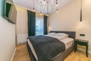 sypialnia z łóżkiem i żyrandolem w obiekcie House Managers - Nadmotławie w Gdańsku