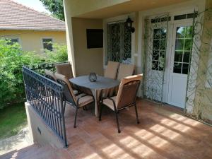 a table and chairs on a patio with a television at Villa Pelso in Balatongyörök