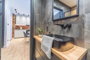 łazienka z czarną umywalką i kuchnią w obiekcie House Managers - Nadmotławie w Gdańsku