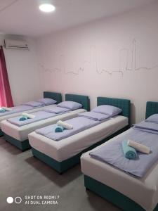a group of four beds in a room at Markaz Apartman Bihac in Bihać