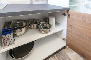 a kitchen with pots and pans on a shelf at Apartments & Rooms Strčić Krk in Krk