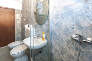 a bathroom with a toilet and a sink and a mirror at Apartments & Rooms Strčić Krk in Krk