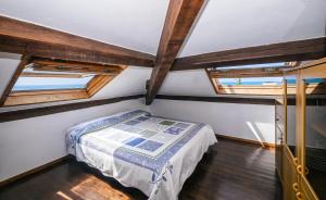 a bedroom with a bed and two windows at Tinetto Brezza di mare in Deiva Marina