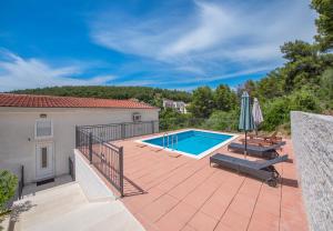 een zwembad op een patio met een huis bij Apartmani Petracie in Drvenik