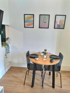 stół i krzesła w pokoju z obrazami w obiekcie T1 le Pastel Parking Netflix Wifi Gare w mieście Évreux