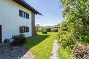 ein Haus mit einem Rasenplatz neben einem Gebäude in der Unterkunft Ferienwohnung Heinrich in Gmund am Tegernsee