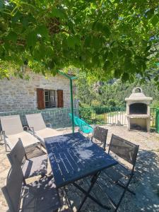 une table de pique-nique bleue et des chaises sous un arbre dans l'établissement Gite la maison de Jules, à Sainte-Énimie