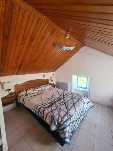 - une chambre avec un lit et un plafond en bois dans l'établissement Gite la maison de Jules, à Sainte-Énimie