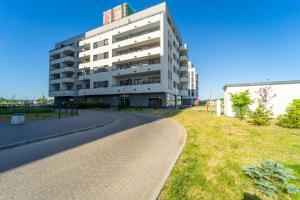 un gran edificio blanco con una carretera delante en Apartament Marynarska Aquapark, en Reda