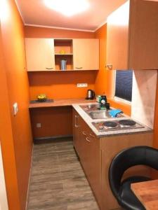 a small kitchen with orange walls and a sink at Vesturgata 44 in Keflavík