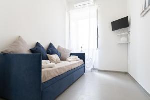 um sofá azul num quarto branco com uma janela em Lighthouse Apartment em Taormina