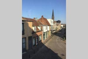 a view of a street with houses and a church at Sas van Gent, luxe appartement in centrum in Sas van Gent