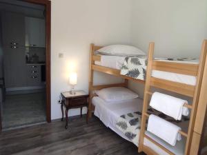 a bedroom with two bunk beds and a table with a lamp at Apartment Bella Costa I in Kaštela