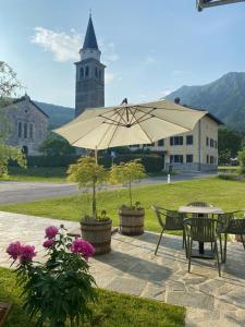 a patio with a table and a large umbrella at Apartment Bandaron in Kobarid