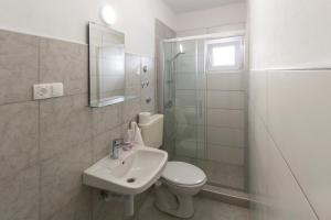 a bathroom with a toilet and a sink and a shower at Apartments & Rooms Strčić Krk in Krk