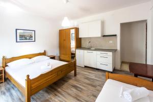 a large bedroom with a bed and a kitchen at Apartments & Rooms Strčić Krk in Krk