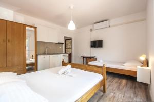 a large room with two beds and a kitchen at Apartments & Rooms Strčić Krk in Krk