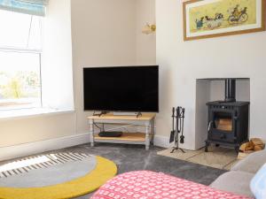 a living room with a flat screen tv and a fireplace at East Hill Farm in Truro