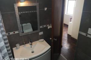 een badkamer met een wastafel en een spiegel bij Apart Hotel Don Ernesto in Lima