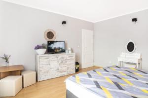 a bedroom with a bed and a tv on a dresser at Lawendowy Dworek in Karpacz