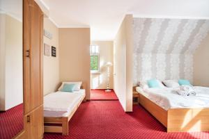 1 Schlafzimmer mit 2 Betten und einem roten Teppich in der Unterkunft Lawendowy Dworek in Karpacz + 99 Fotos