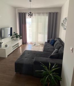 sala de estar con sofá negro y TV en Villa Moon Trogir, en Trogir