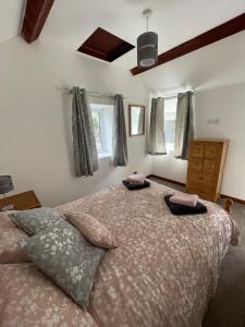 a bedroom with a large bed with two pillows on it at Cwt Mochyn in Corwen