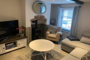 a living room with a couch and a tv and a table at Grade II listed, town house in Monmouth