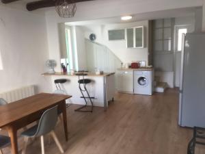 a kitchen and living room with a table and chairs at Maison de village, les hirondelles in Cadenet