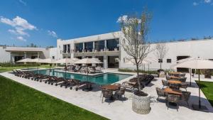 a pool with chairs and umbrellas in front of a building at Casa Itzae La Luminaria Dog Friendly in San Miguel de Allende