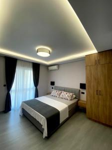 sypialnia z dużym łóżkiem i dużym oknem w obiekcie Apartments Grabovica w Barze