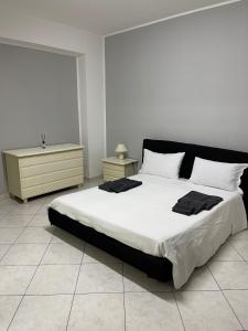 una camera da letto con un grande letto con lenzuola bianche di IL QUADRIFOGLIO intero appartamento centro città a Villa San Giovanni