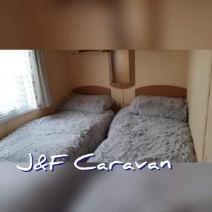 two beds sitting next to each other in a bedroom at J & F caravan in Skegness