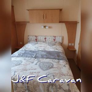 Una cama en una habitación pequeña con un colchón en J & F caravan, en Skegness