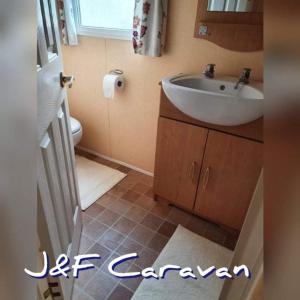 ein Badezimmer mit einem weißen Waschbecken und einem WC in der Unterkunft J & F caravan in Skegness