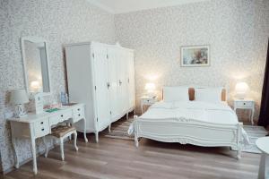 a white bedroom with a bed and a dresser at Abastumani Residence in Abastumani
