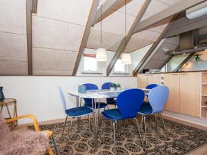 リンケビングにあるHoliday home Ringkøbing VIIIのダイニングルーム(テーブル、青い椅子付)