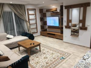 a living room with a couch and a tv at Alcasar Beach 3 rooms apartment in Sousse