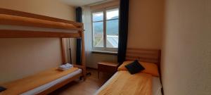 two bunk beds in a room with a window at Bahnhof West Apartments in Interlaken