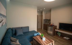 a living room with a blue couch and a kitchen at Villa Morfeas in Paralia Katerinis