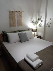 a bedroom with a white bed with towels on it at Amare Luxury Living in Volos