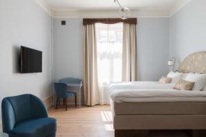 a room with a bed, chair, television and a window at Hotel Ruth, WorldHotels Crafted in Stockholm