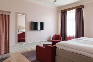 a hotel room with a large bed and a television at Hotel Ruth, WorldHotels Crafted in Stockholm