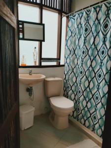 a bathroom with a toilet and a sink and a window at Hostal El Bohío in Palomino +28 photos