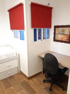 1 dormitorio con escritorio y silla junto a la cama en Apartamento Zona Carrefour, en El Puerto de Santa María