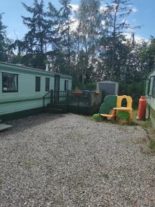 a campsite with a green trailer and a house at Lochlands caravan park X(6) in Forfar